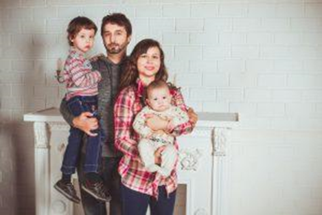 A family with kids posing in a home.